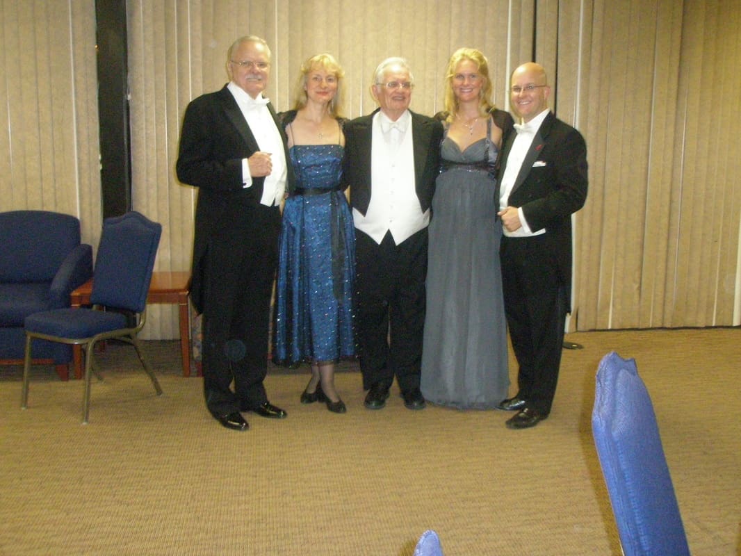 A group of people in formal wear posing for the camera.
