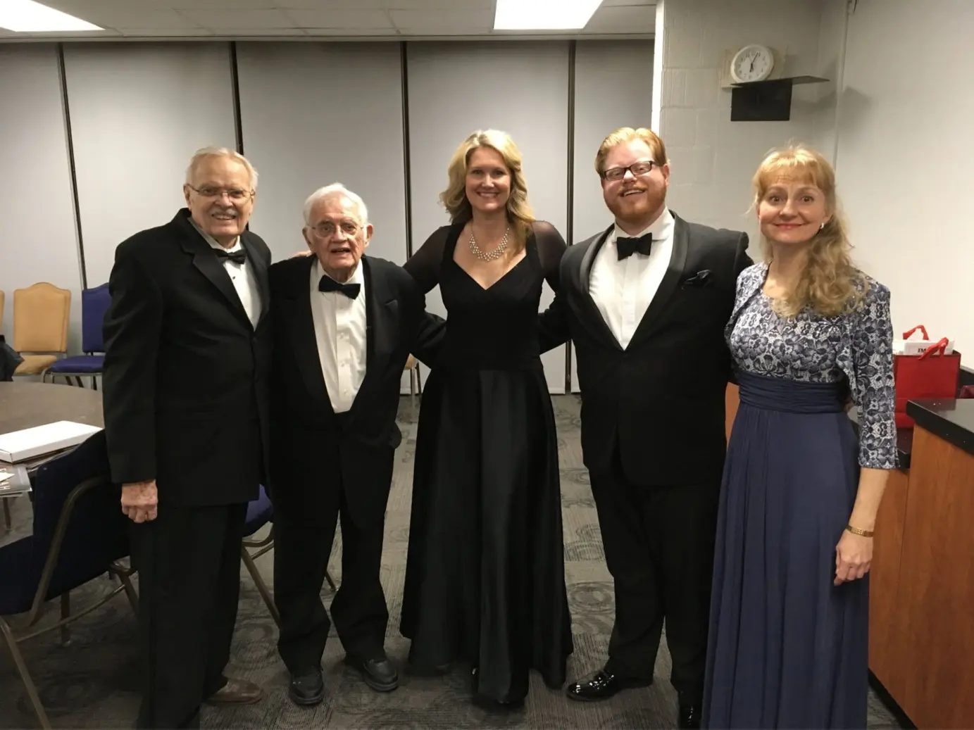 A group of people in formal wear posing for the camera.